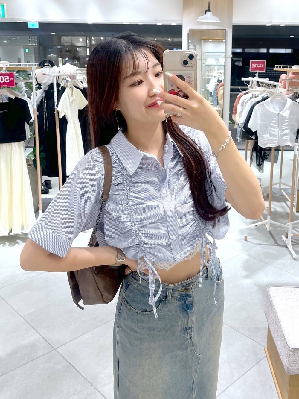 ブラウン系のショルダーバッグ、ホワイト系のキャミソール、ブラック系のサンダルを着用したレディースの夏コーディネートの4枚目の写真