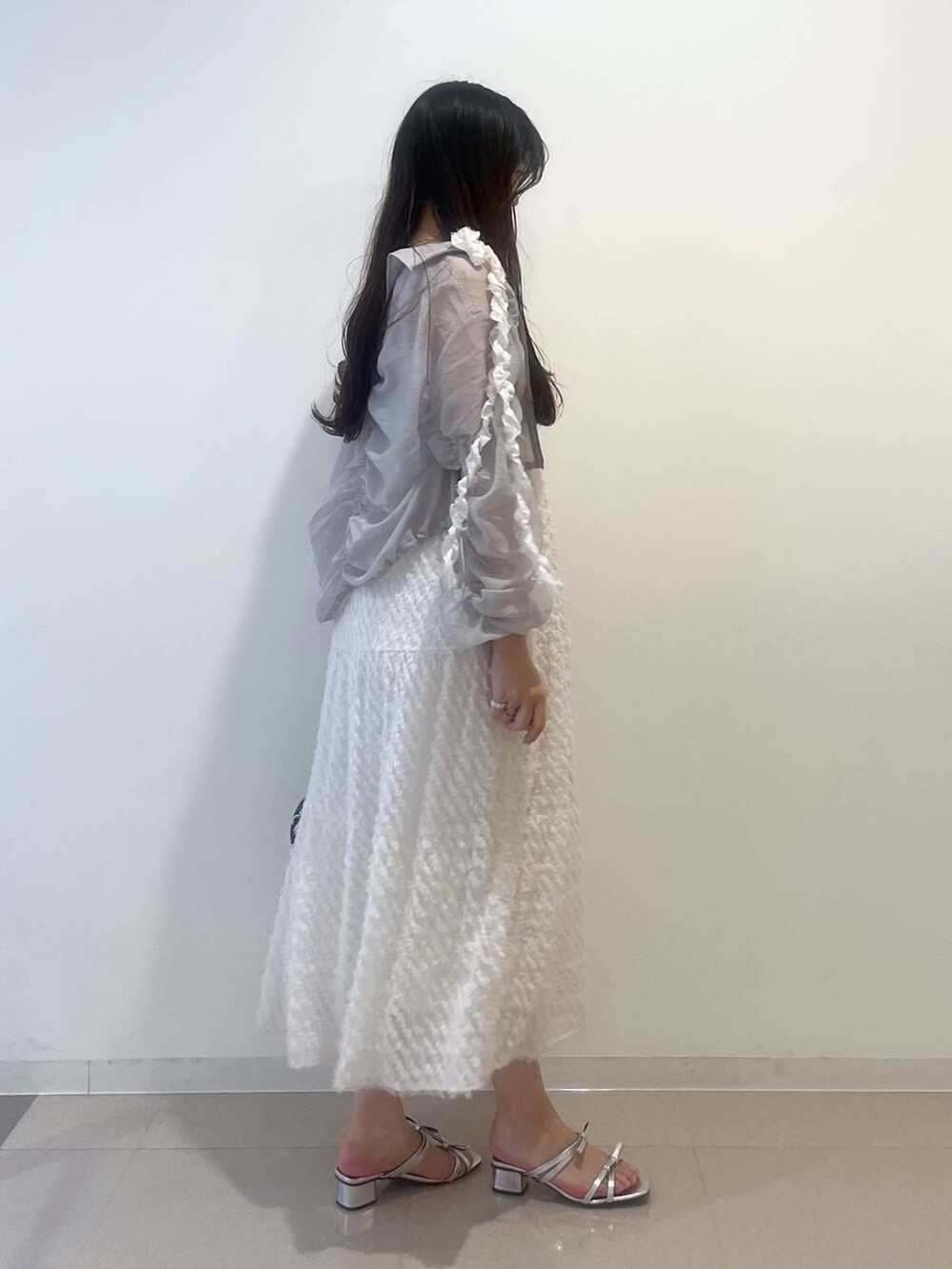 シルバー系のサンダル、ホワイト系のワンピース、グレー系のブルゾンを着用したレディースの春コーディネートの5枚目の写真