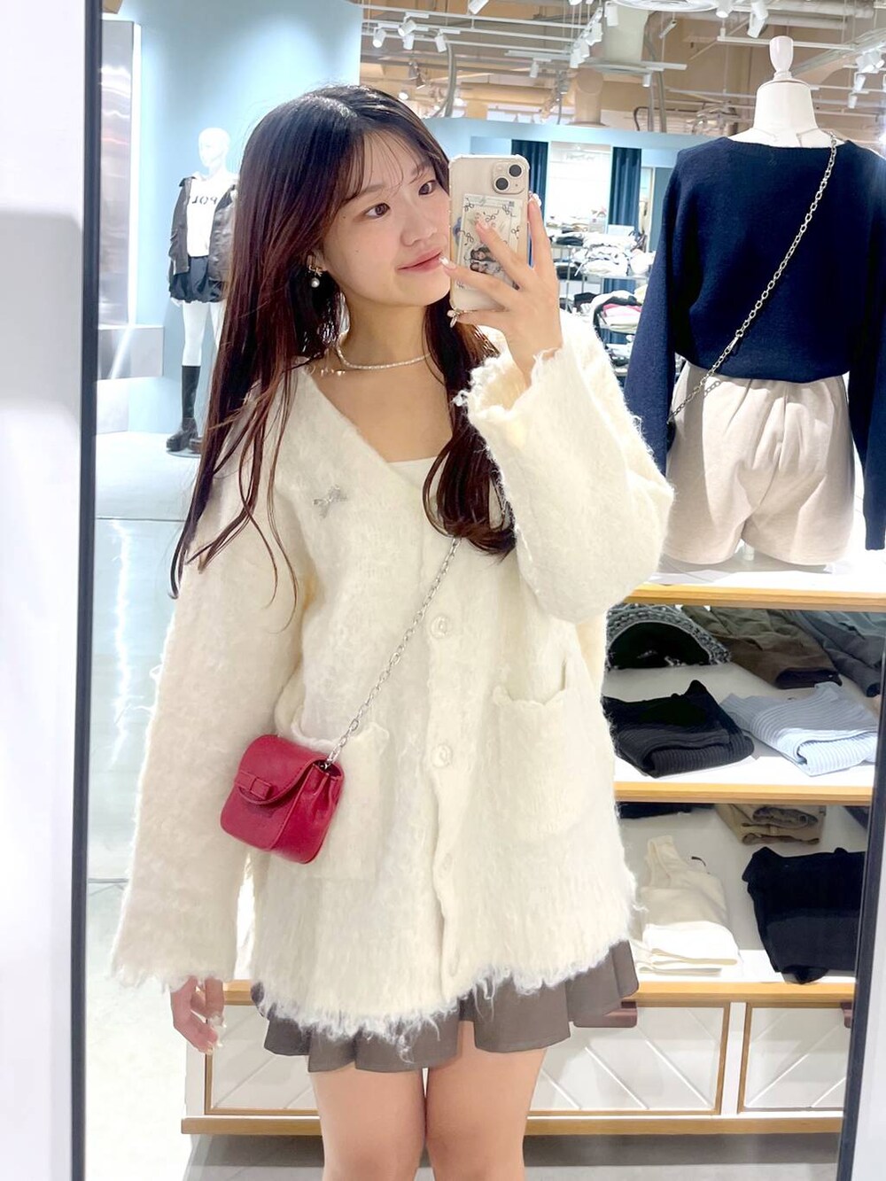 ブラウン系のスカート、ホワイト系のカーディガン/ボレロ、ベージュ系のブーツを着用したレディースの秋コーディネートの9枚目の写真