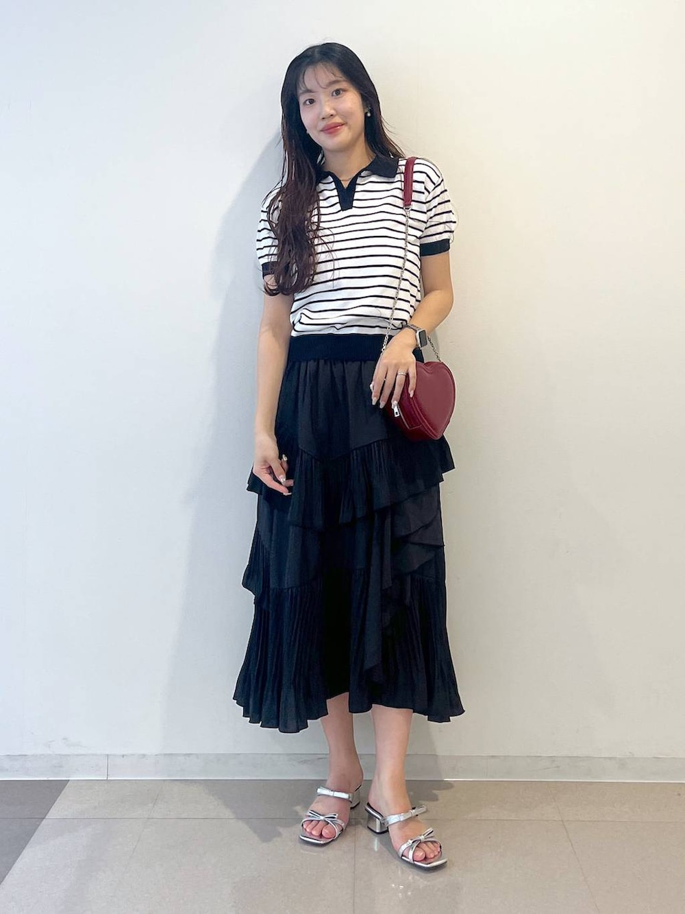 ホワイト系のキャミソール、ブラック系のスカート、シルバー系のサンダルを着用したレディースの春コーディネートの7枚目の写真