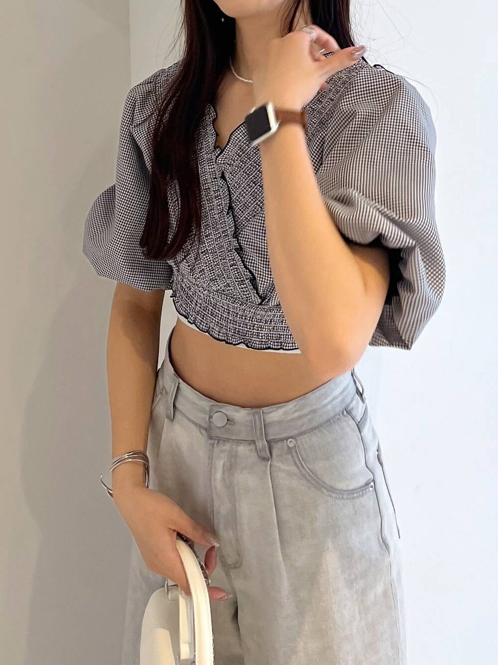 シルバー系のサンダル、ホワイト系のキャミソール、グレー系のデニムパンツを着用したレディースの春コーディネートの4枚目の写真