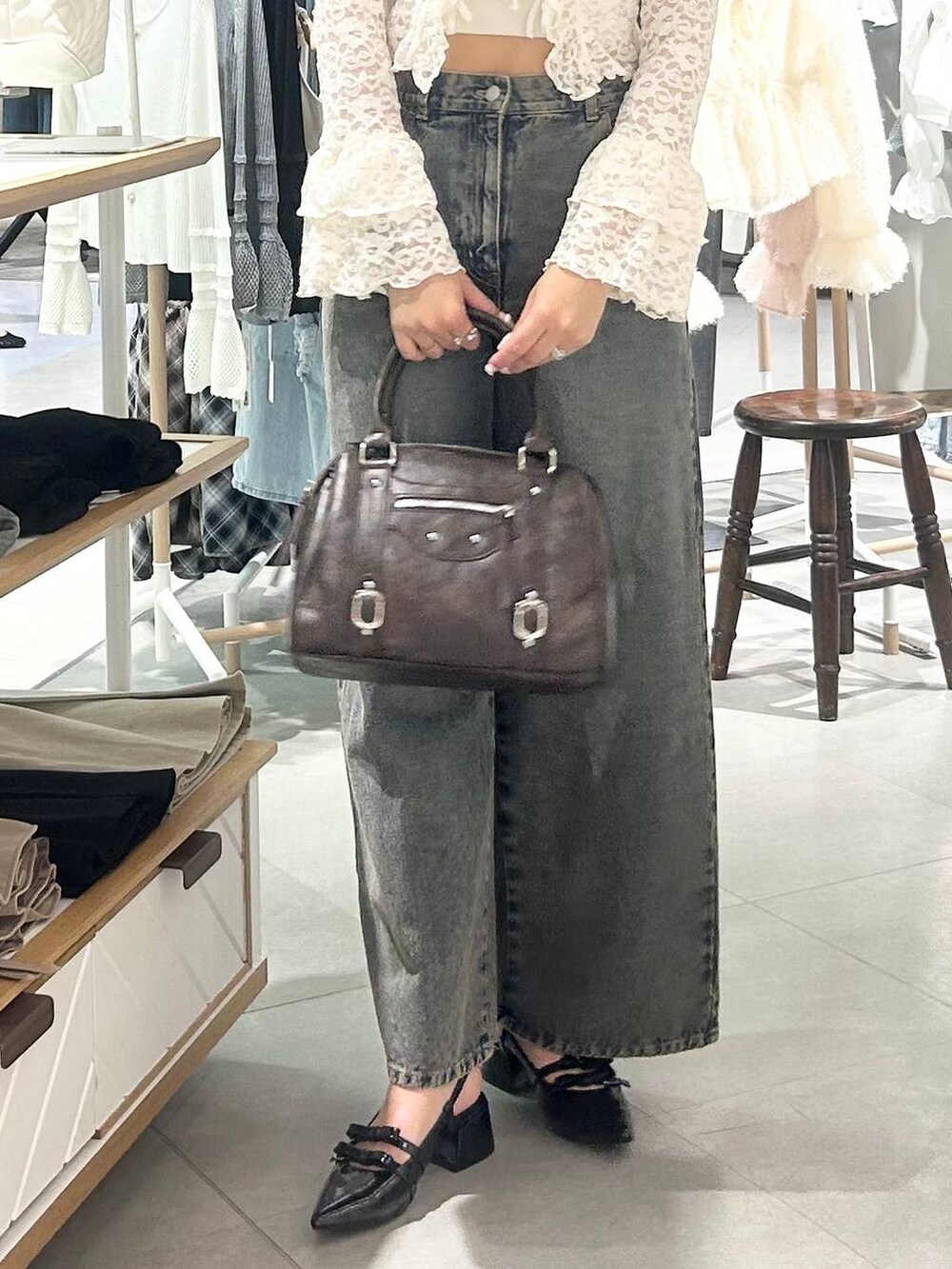 ホワイト系のキャミソール、ブルー系のデニムパンツ、ブラウン系のボストンバッグを着用したレディースの春コーディネートの9枚目の写真