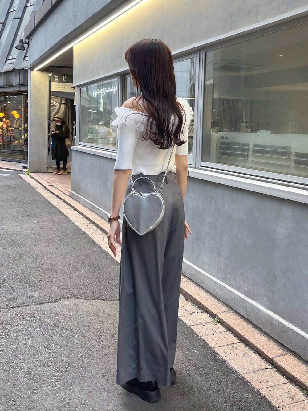 シルバー系のショルダーバッグ、グレー系のスラックス、ホワイト系のキャミソールを着用したレディースの春コーディネートの3枚目の写真