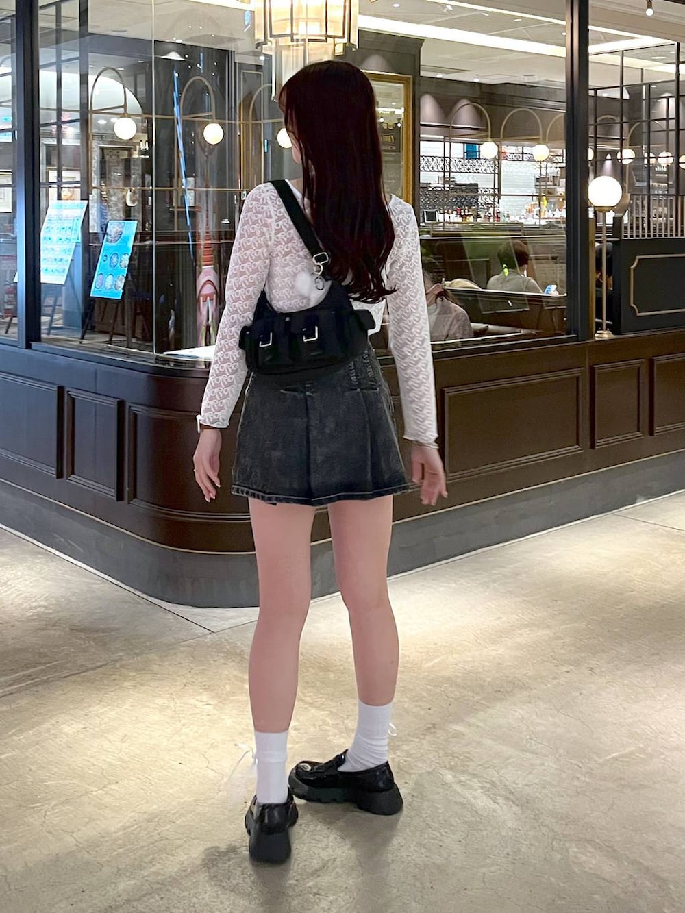 ブラック系のショルダーバッグ、ブラック系のローファー、ブラック系のデニムスカートを着用したレディースの春コーディネートの7枚目の写真