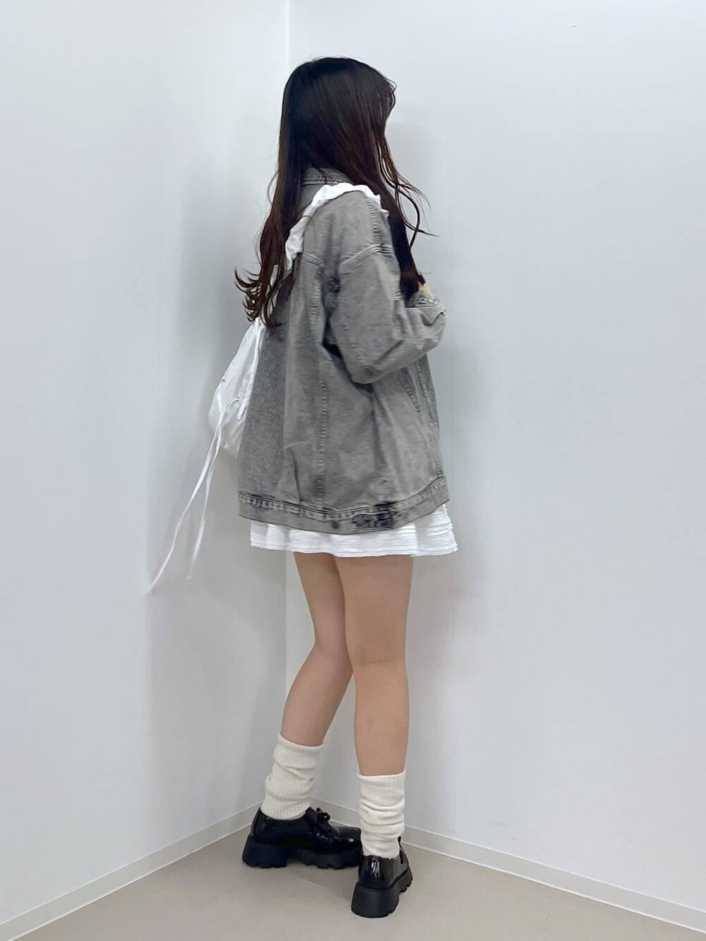 ホワイト系のTシャツ/カットソー、ブラック系のドレスシューズ、ホワイト系のニット/セーターを着用したレディースの冬コーディネートの4枚目の写真