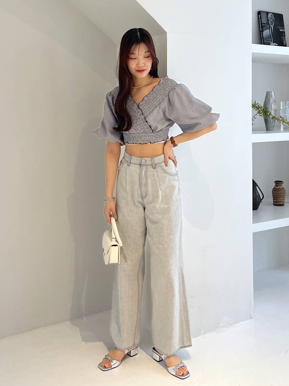 シルバー系のサンダル、ホワイト系のキャミソール、グレー系のデニムパンツを着用したレディースの春コーディネートの3枚目の写真