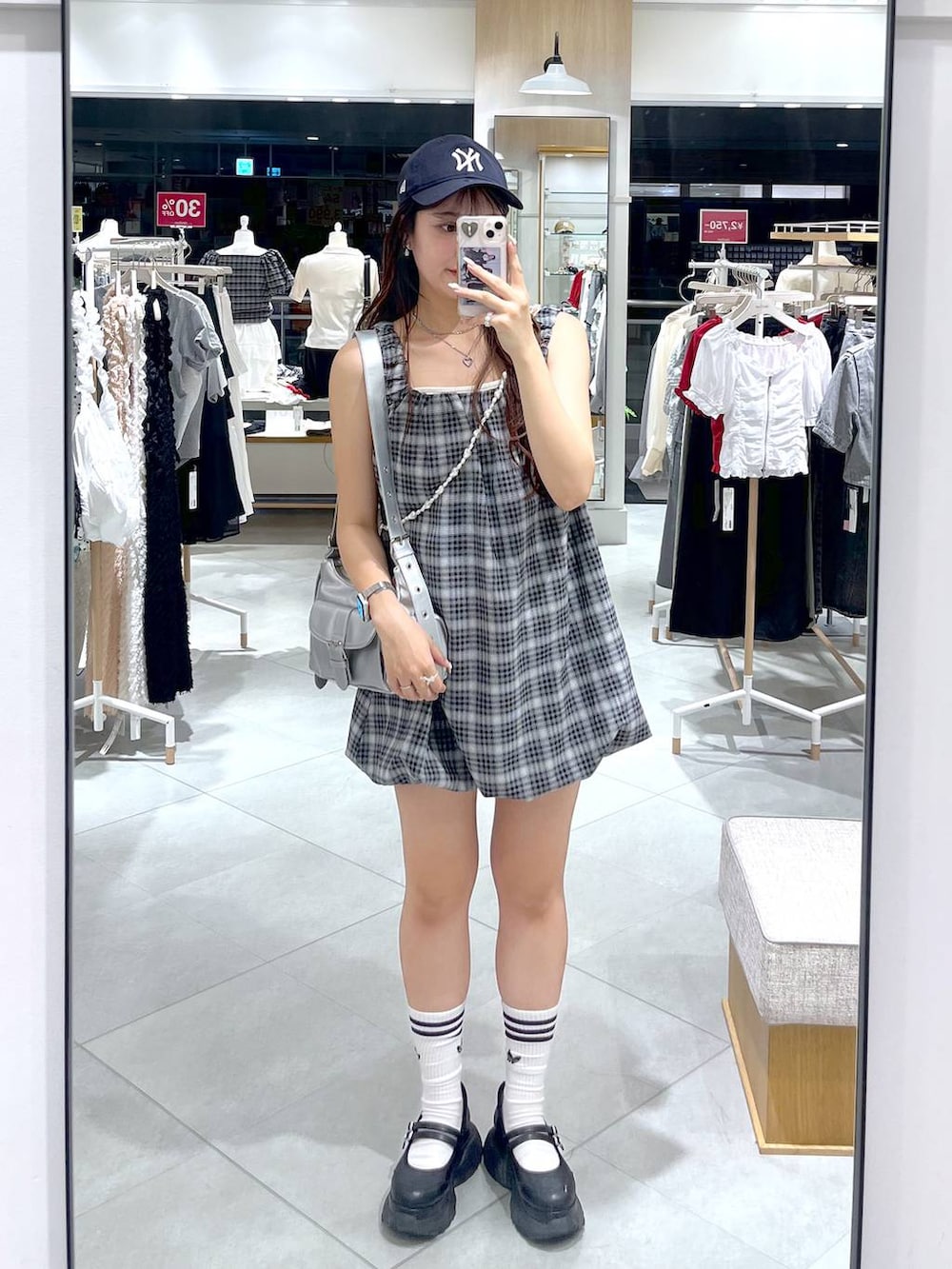 ブラック系のスニーカー、ホワイト系のキャミソール、シルバー系のショルダーバッグを着用したレディースの夏コーディネートの6枚目の写真