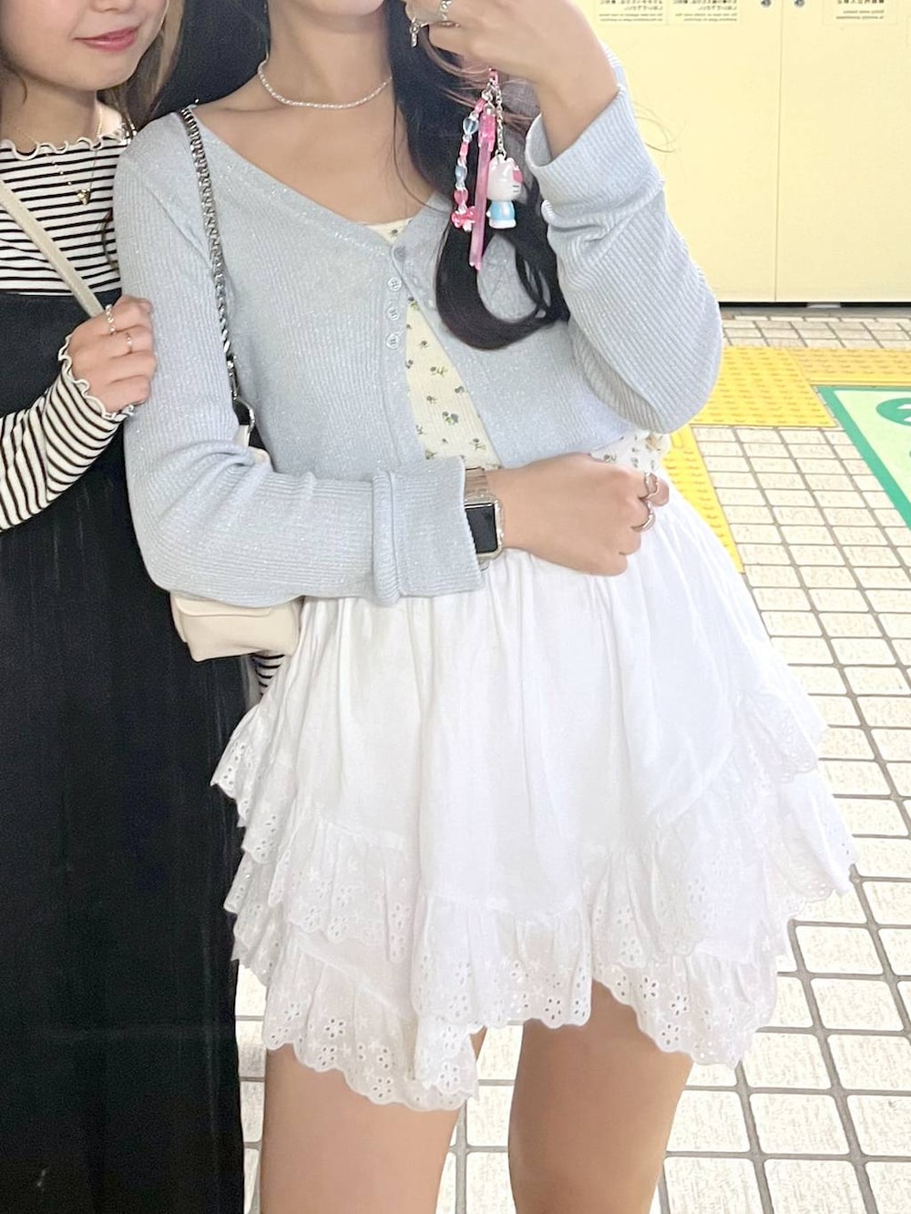 ホワイト系のキャミソール、ホワイト系のショルダーバッグ、ブルー系のカーディガン/ボレロを着用したレディースの春コーディネートの4枚目の写真