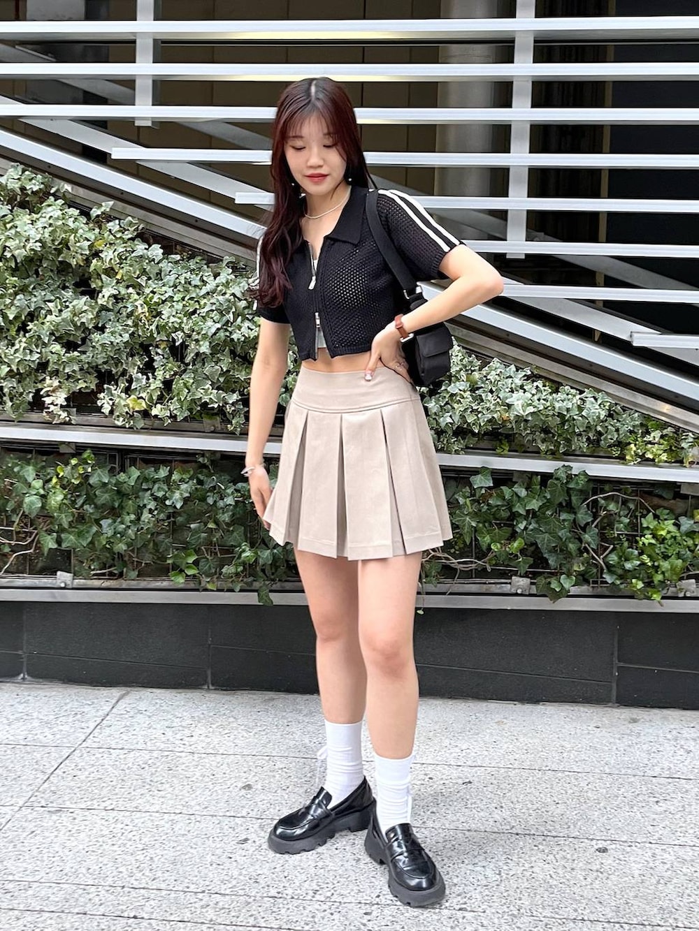 ブラック系のショルダーバッグ、ホワイト系のキャミソール、ブラック系のローファーを着用したレディースの夏コーディネートの2枚目の写真