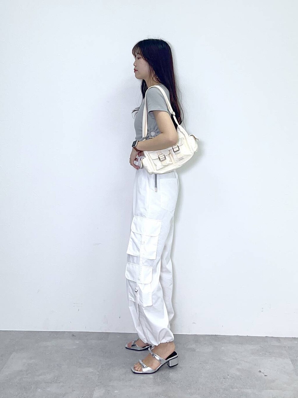ホワイト系のショルダーバッグ、ホワイト系のカーゴパンツ、シルバー系のサンダルを着用したレディースの春コーディネートの2枚目の写真