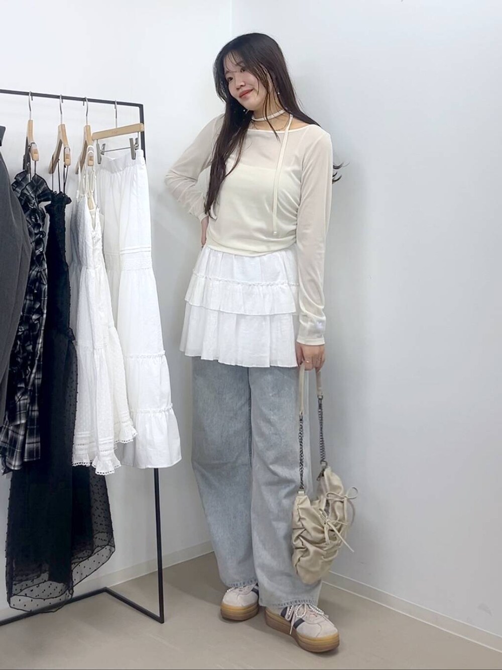 ホワイト系のキャミソール、ブルー系のデニムパンツ、ホワイト系のスカートを着用したレディースの春コーディネートの7枚目の写真