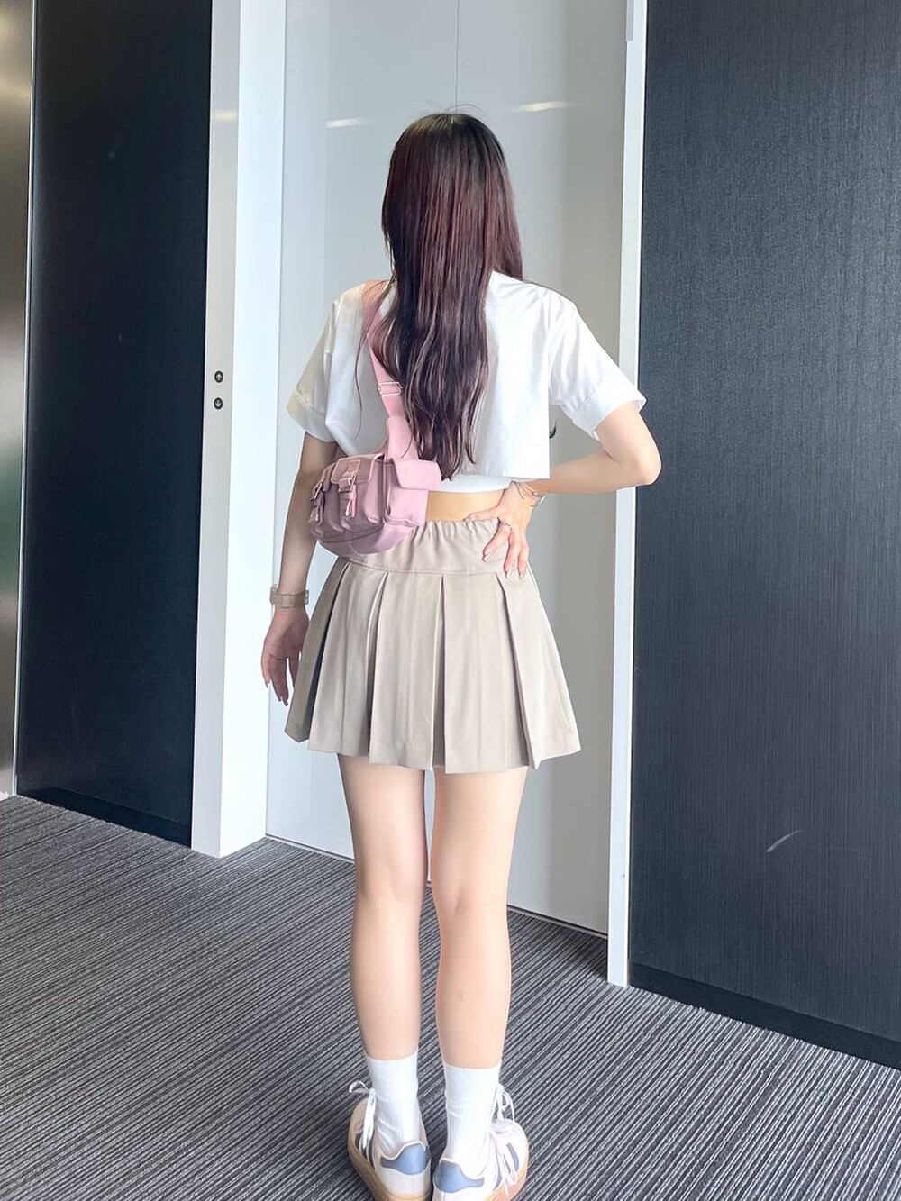 ピンク系のショルダーバッグ、ホワイト系のキャミソール、ベージュ系のスカートを着用したレディースの夏コーディネートの4枚目の写真