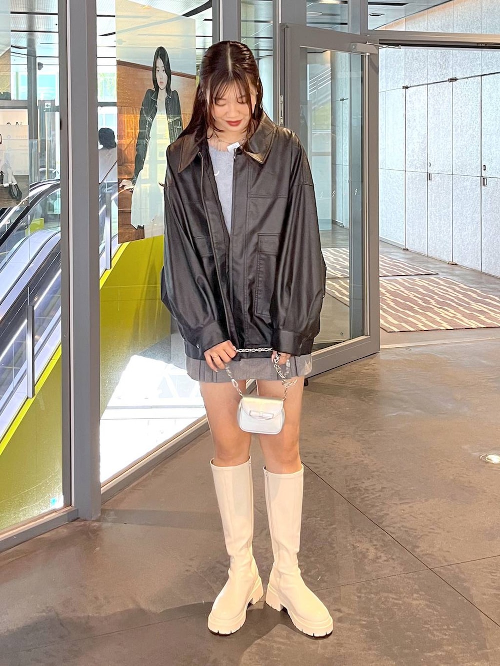 グレー系のスカート、ブルー系のカーディガン/ボレロ、ホワイト系のブーツを着用したレディースの秋コーディネートの6枚目の写真