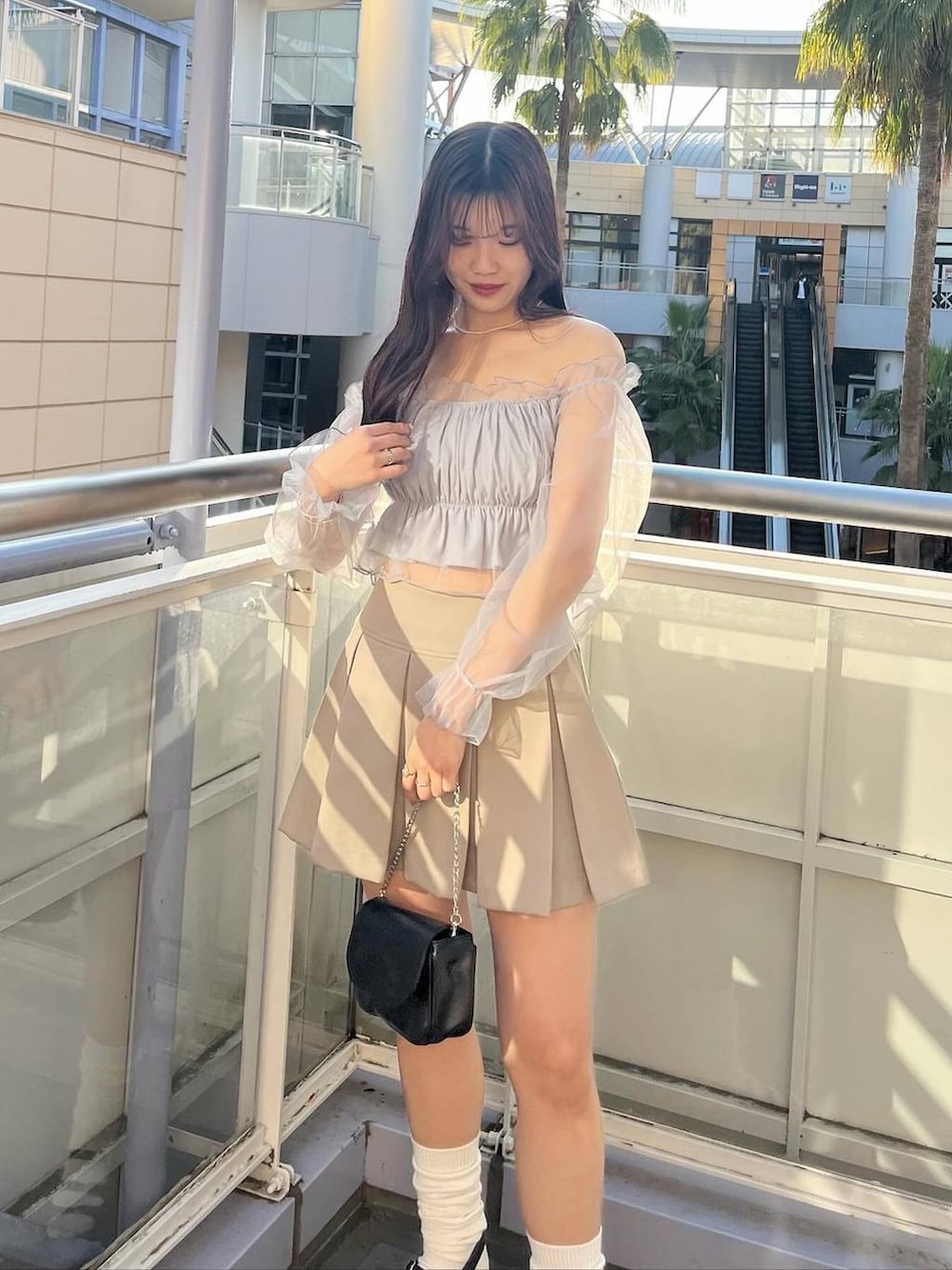 ブラック系のショルダーバッグ、グレー系のシャツ/ブラウス、ホワイト系のキャミソールを着用したレディースの春コーディネートの5枚目の写真