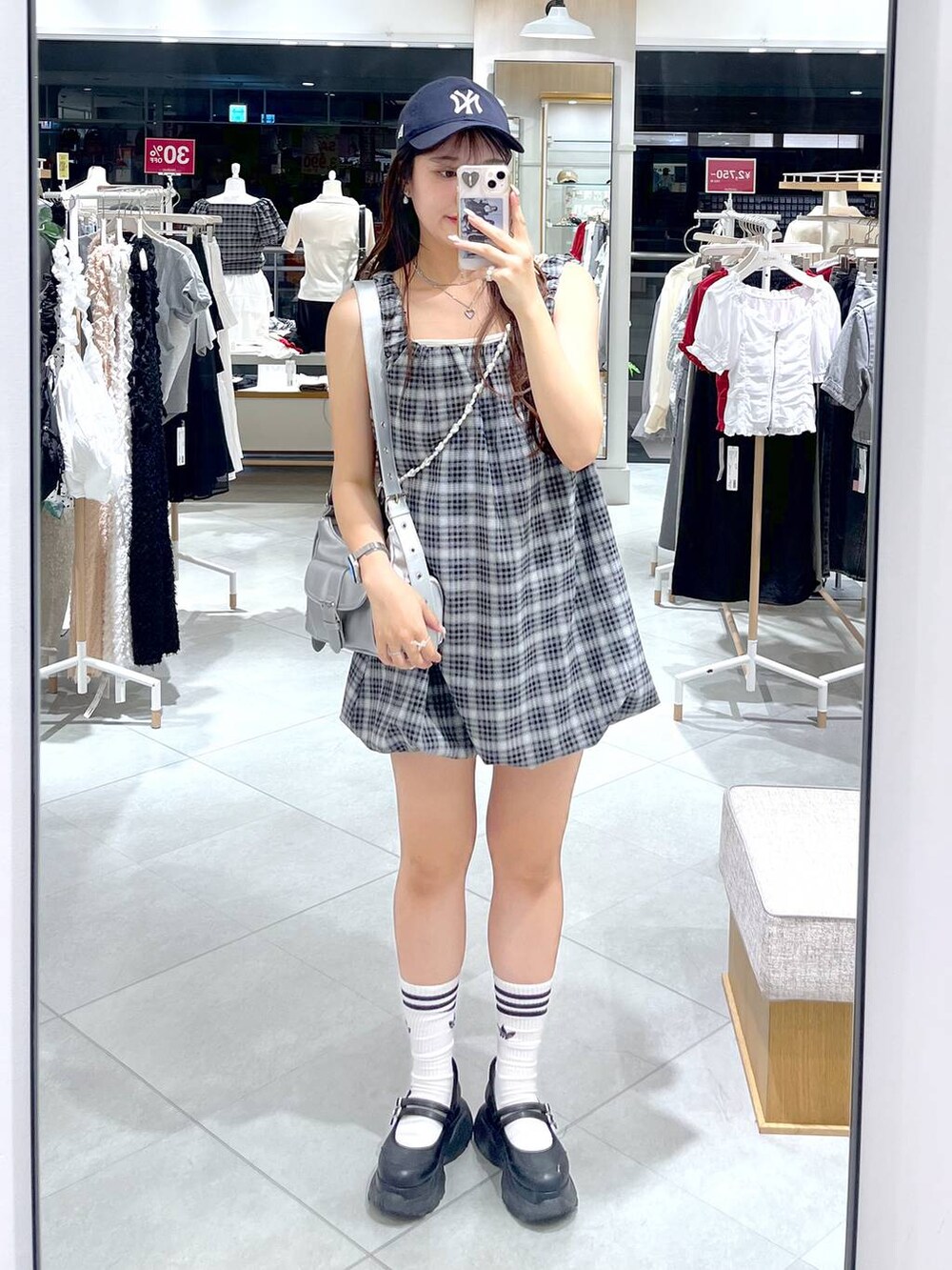 ブラック系のスニーカー、ホワイト系のキャミソール、シルバー系のショルダーバッグを着用したレディースの夏コーディネートの4枚目の写真