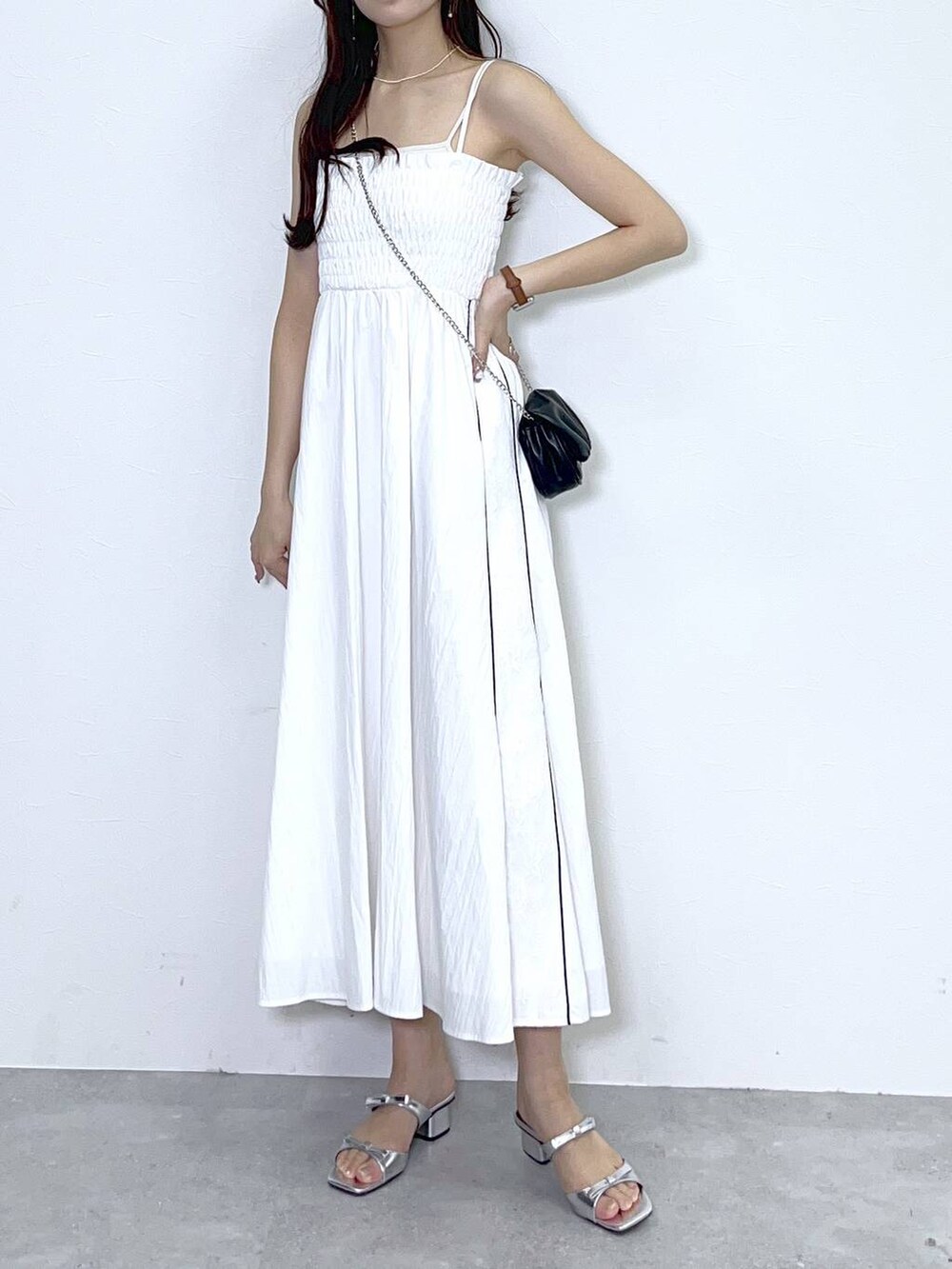 ブラック系のショルダーバッグ、ホワイト系のキャミソール、シルバー系のサンダルを着用したレディースの春コーディネートの6枚目の写真