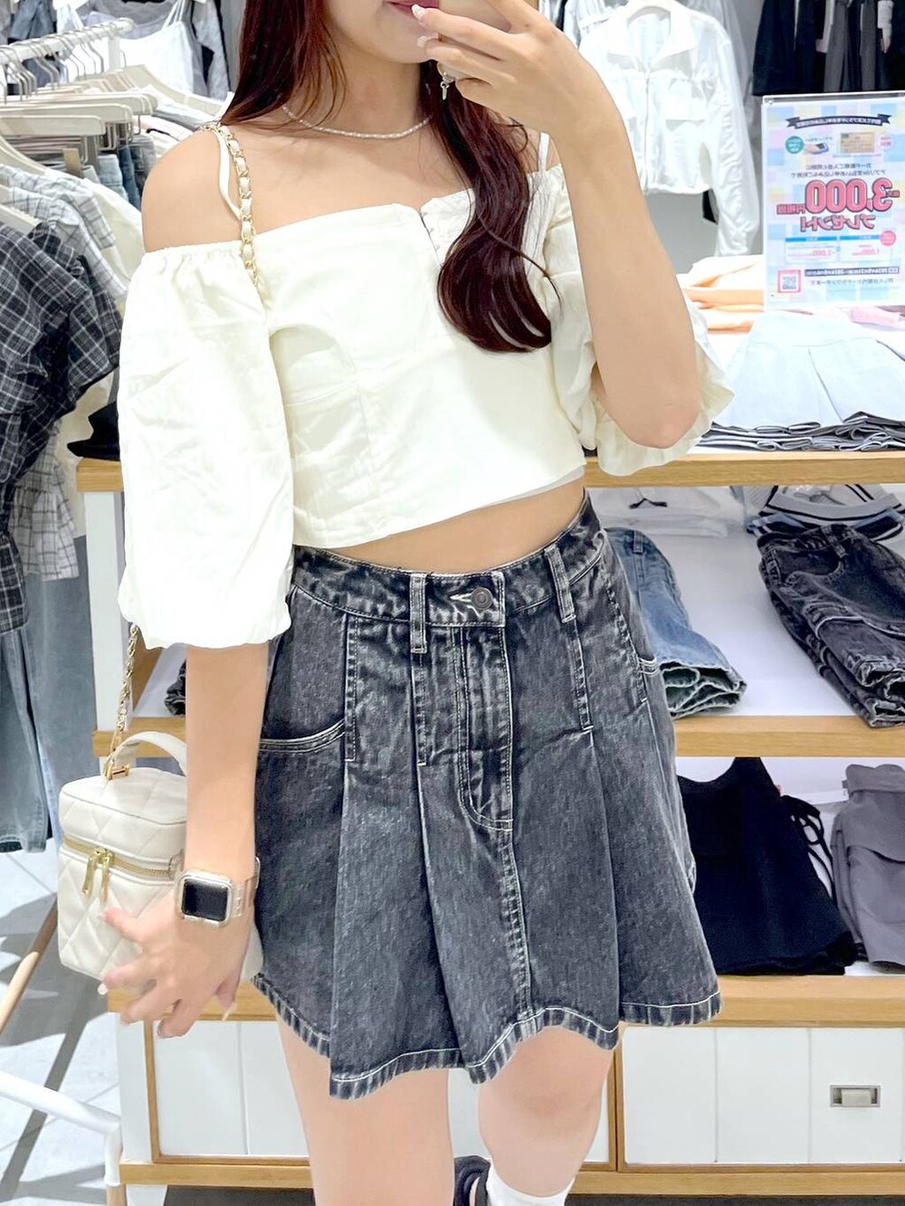 ブラック系のデニムスカート、ブラック系のサンダル、ホワイト系のショルダーバッグを着用したレディースの夏コーディネートの9枚目の写真