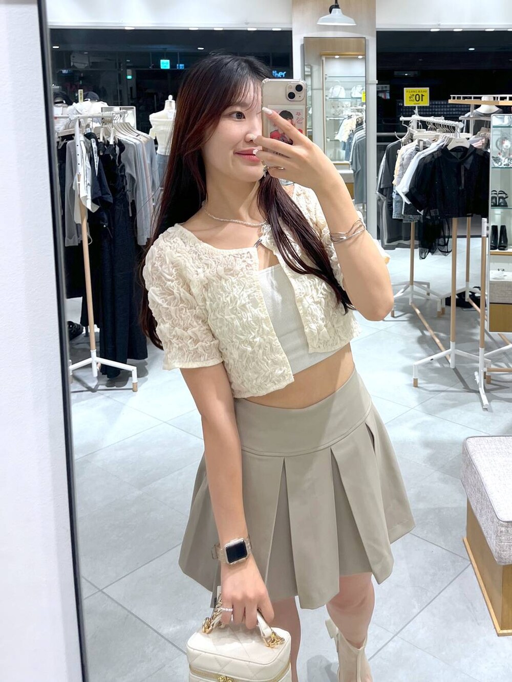 ホワイト系のカーディガン/ボレロ、ホワイト系のキャミソール、ホワイト系のショルダーバッグを着用したレディースの夏コーディネートの2枚目の写真