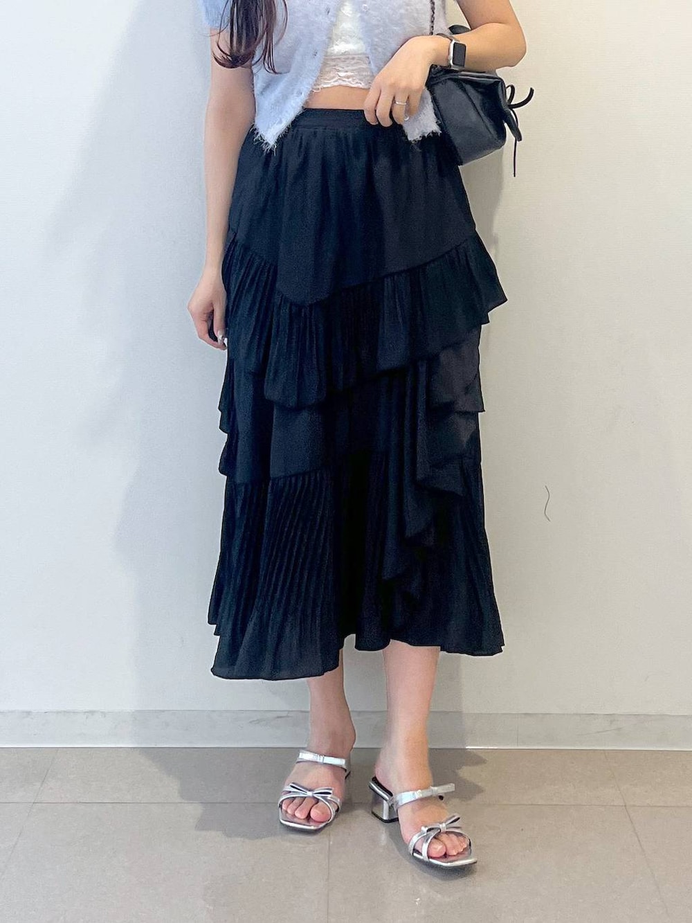 グレー系のショルダーバッグ、ブラック系のスカート、ホワイト系のキャミソールを着用したレディースの春コーディネートの7枚目の写真