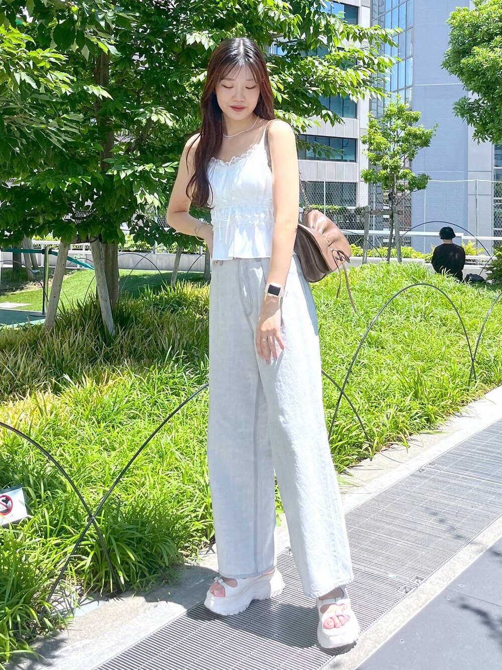 ホワイト系のキャミソール、グレー系のデニムパンツ、ホワイト系のサンダルを着用したレディースの夏コーディネートの5枚目の写真