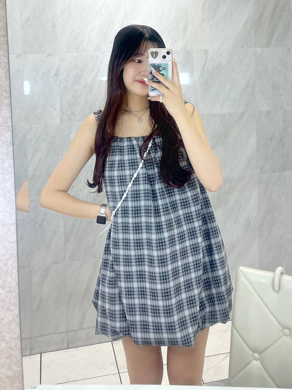 ホワイト系のキャミソール、グレー系のワンピース、シルバー系のネックレスを着用したレディースの夏コーディネートの5枚目の写真