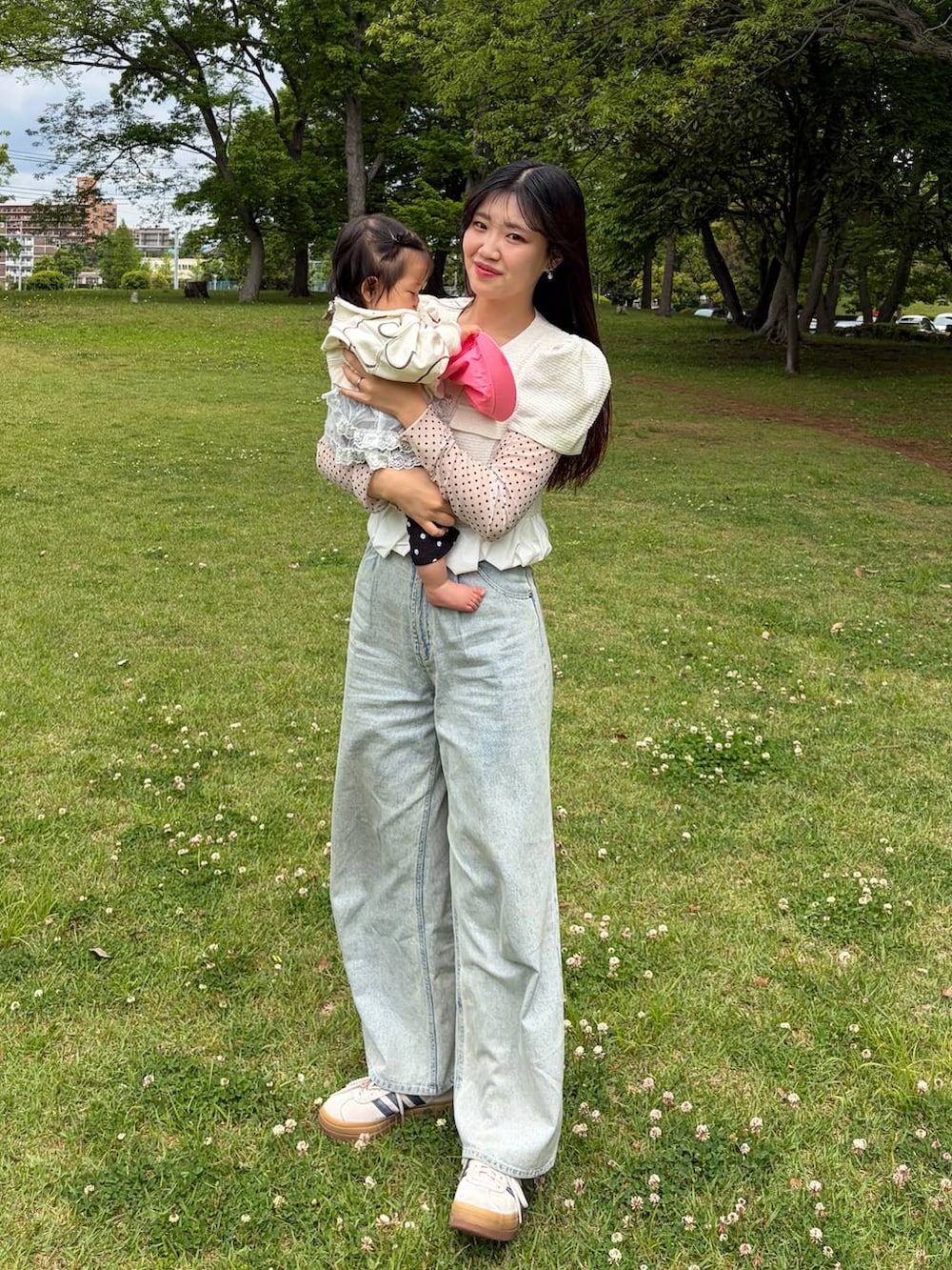 ブルー系のデニムパンツ、ホワイト系のノーカラージャケットを着用したレディースの春コーディネートの2枚目の写真