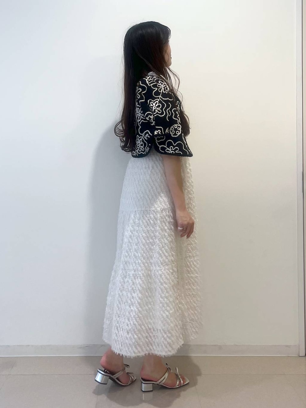 シルバー系のサンダル、ホワイト系のワンピース、ブラック系のショルダーバッグを着用したレディースの春コーディネートの2枚目の写真