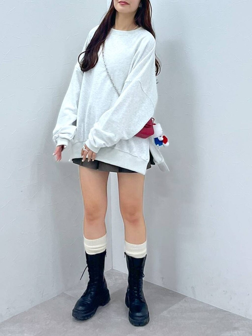 ホワイト系のTシャツ/カットソー、ブラウン系のスカート、レッド系のショルダーバッグを着用したレディースの秋コーディネートの6枚目の写真