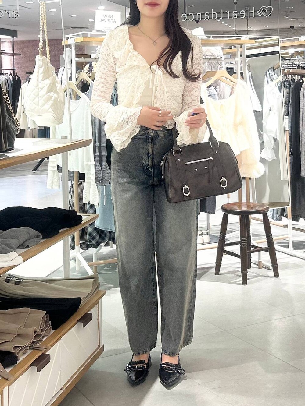 ホワイト系のキャミソール、ブルー系のデニムパンツ、ブラウン系のボストンバッグを着用したレディースの春コーディネートの10枚目の写真