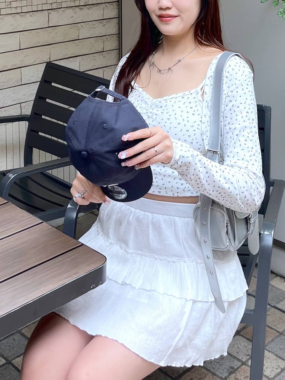 ホワイト系のスカート、ホワイト系のアンサンブル、ホワイト系のキャミソールを着用したレディースの春コーディネートの4枚目の写真