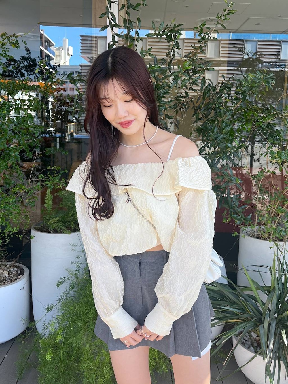 ホワイト系のショルダーバッグ、ホワイト系のキャミソール、ホワイト系のサンダルを着用したレディースの春コーディネートの7枚目の写真