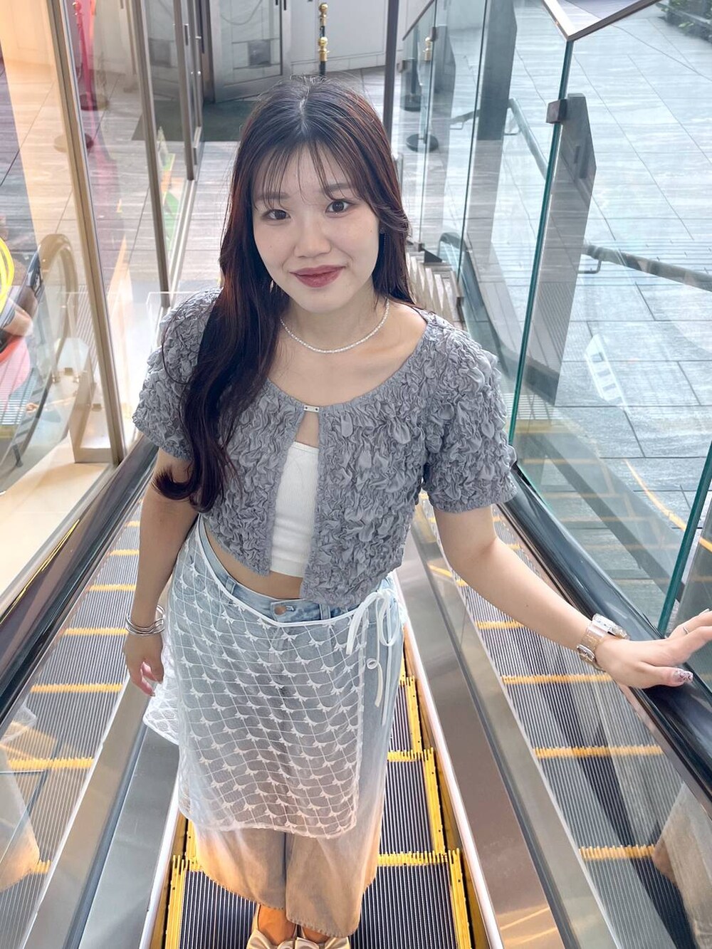 シルバー系のサンダル、ホワイト系のキャミソール、ブルー系のデニムパンツを着用したレディースの夏コーディネートの6枚目の写真