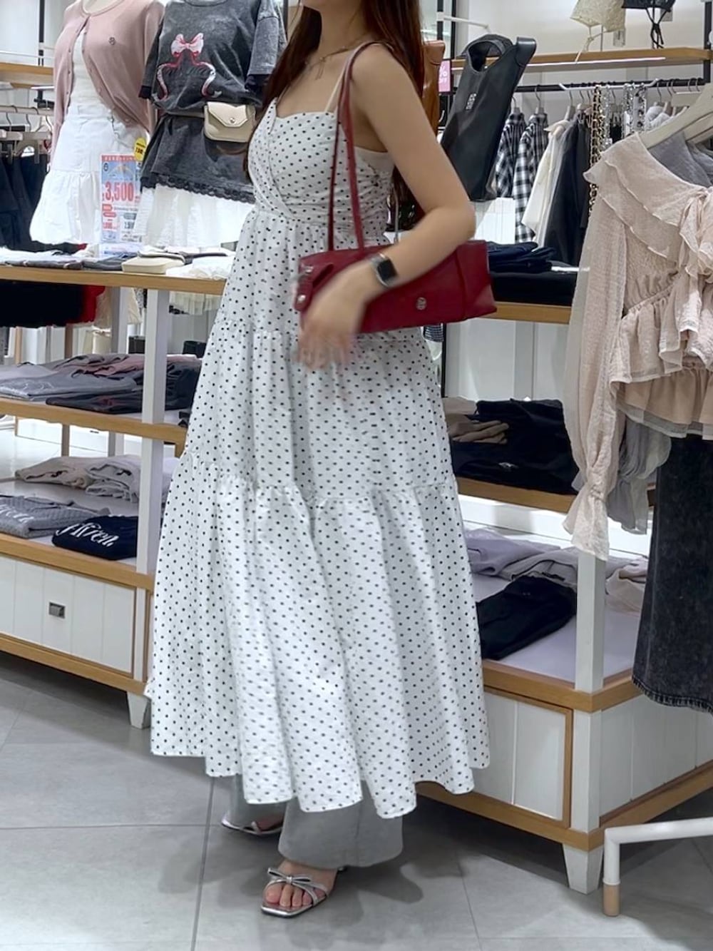 ホワイト系のキャミソール、シルバー系のサンダル、レッド系のボストンバッグを着用したレディースの春コーディネートの3枚目の写真