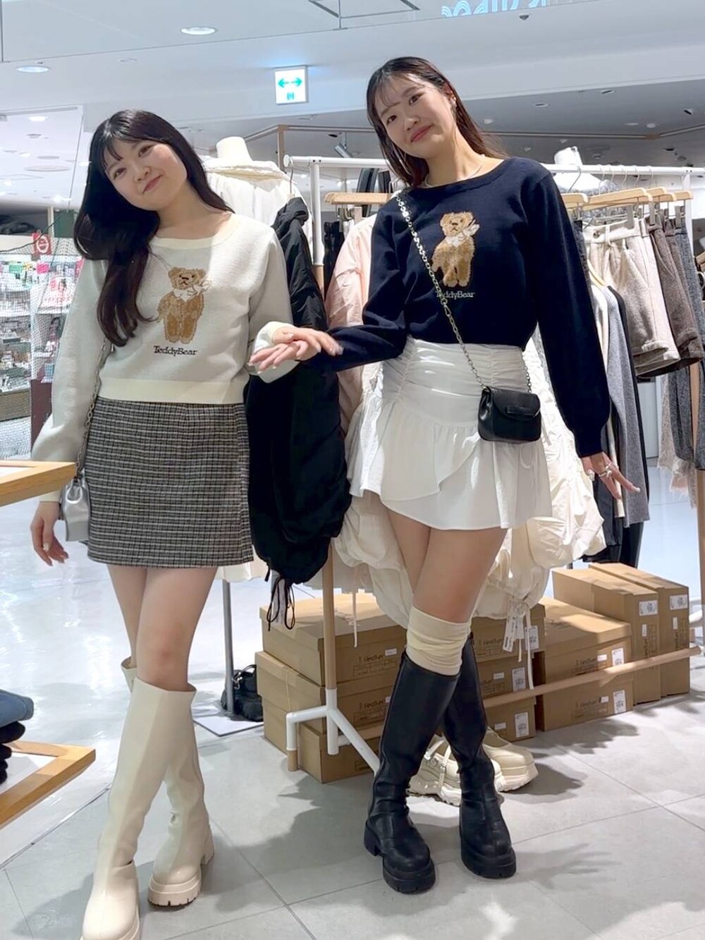 ブラック系のスカート、ブラック系のショルダーバッグ、ブラック系のブーツを着用したレディースの秋コーディネートの5枚目の写真