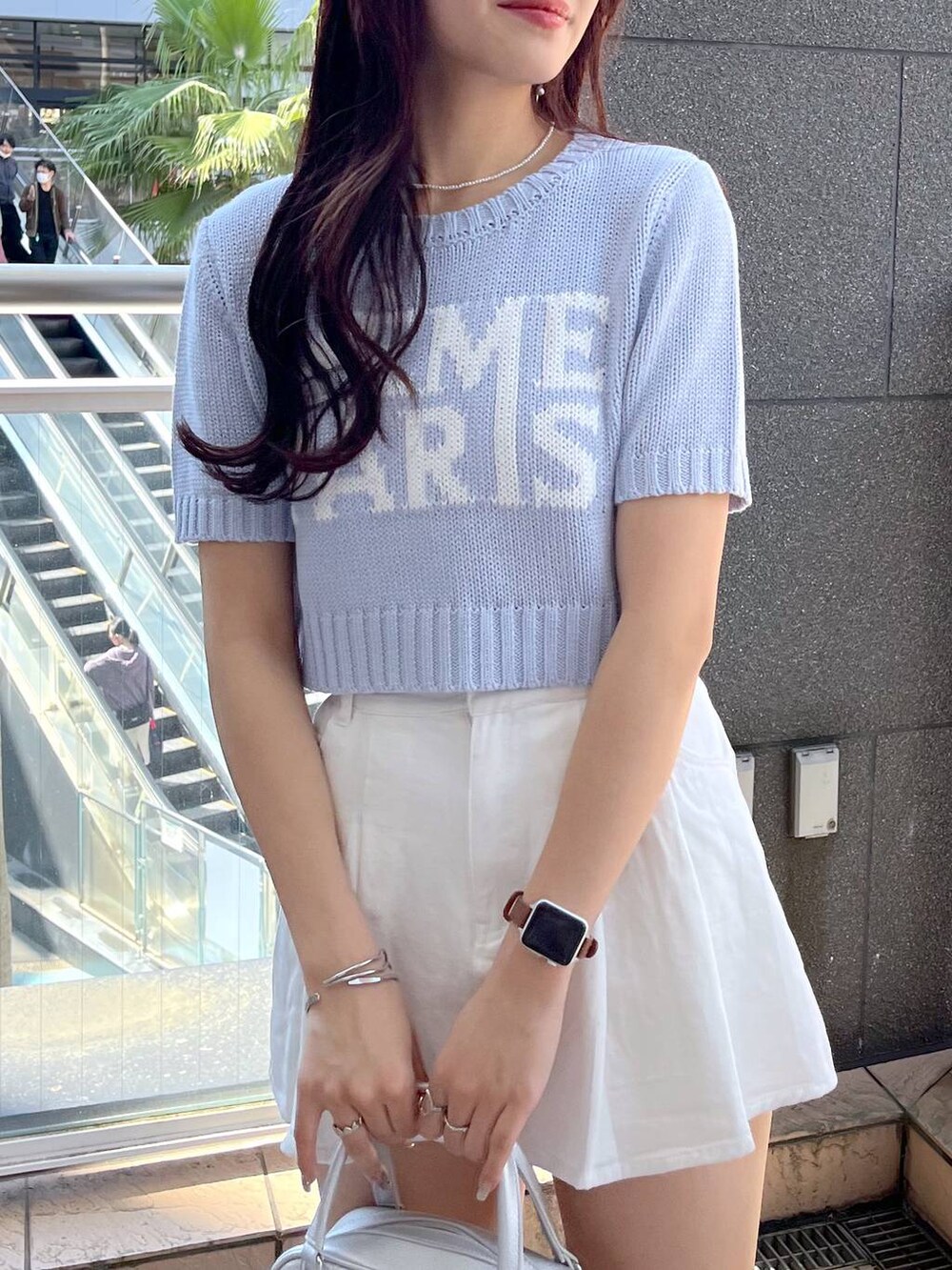 ブラック系のサンダル、ホワイト系のスカート、ブルー系のニット/セーターを着用したレディースの春コーディネートの6枚目の写真