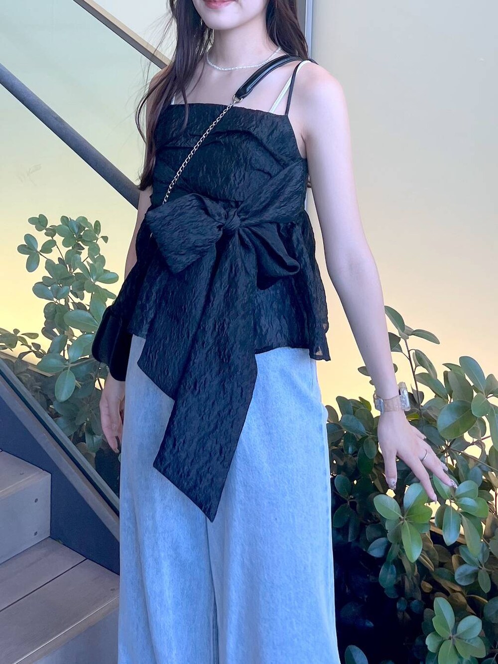 シルバー系のサンダル、ブラック系のショルダーバッグ、ホワイト系のキャミソールを着用したレディースの夏コーディネートの7枚目の写真