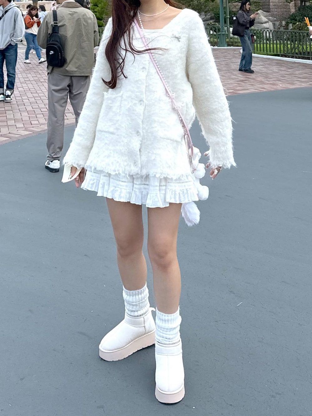 ブラウン系のショルダーバッグ、ホワイト系のTシャツ/カットソー、ホワイト系のブーツを着用したレディースの秋コーディネートの3枚目の写真