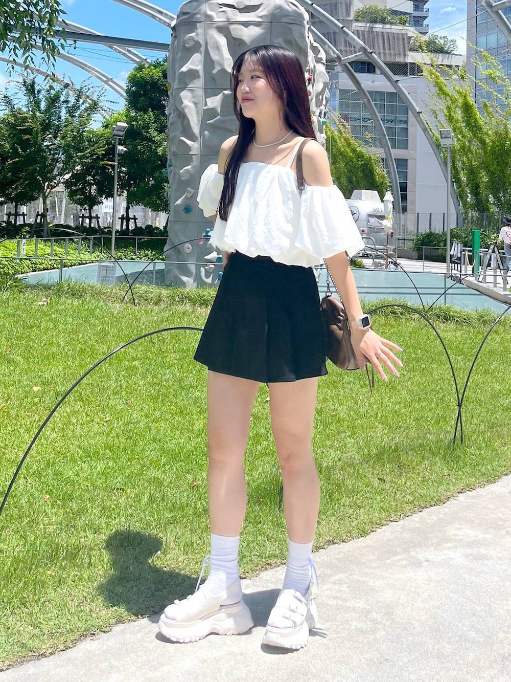 ブラック系のスカート、ホワイト系のシャツ/ブラウス、ホワイト系のキャミソールを着用したレディースの夏コーディネートの4枚目の写真