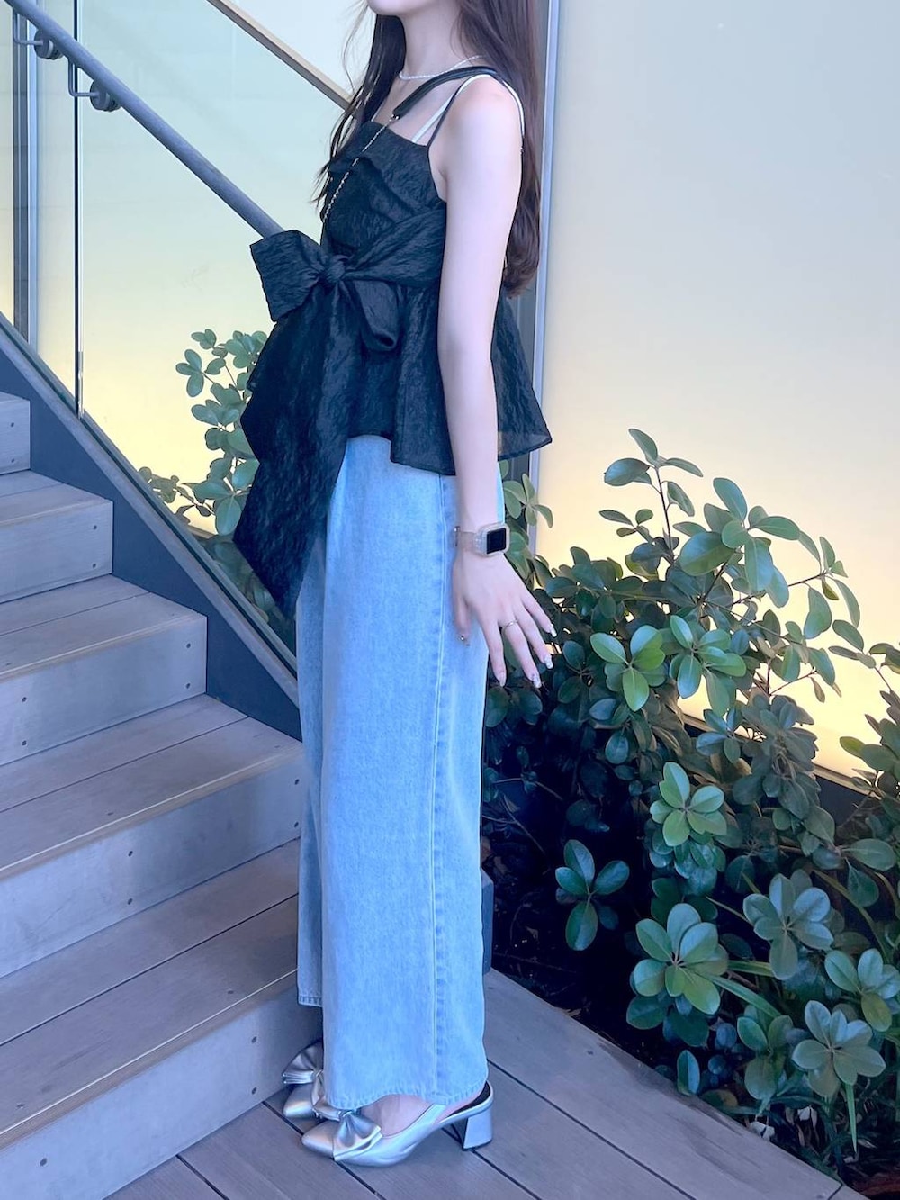 シルバー系のサンダル、ブラック系のショルダーバッグ、ホワイト系のキャミソールを着用したレディースの夏コーディネートの5枚目の写真