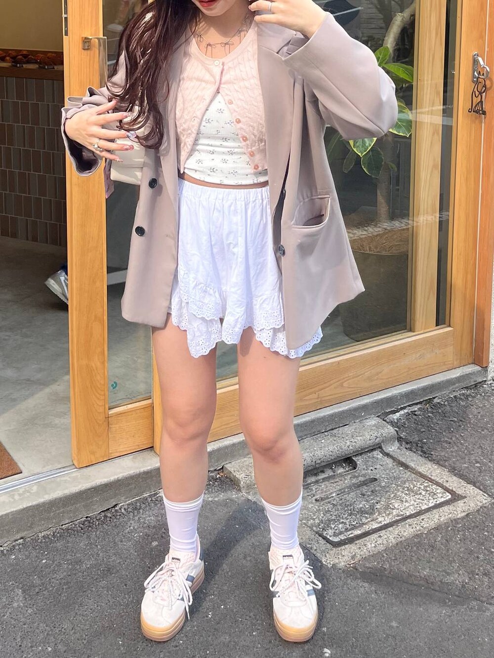 ホワイト系のキャミソール、ホワイト系のカーディガン/ボレロ、シルバー系のネックレスを着用したレディースの春コーディネートの3枚目の写真