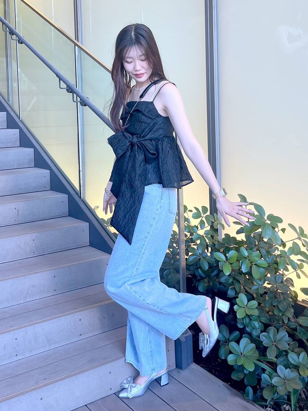 シルバー系のサンダル、ブラック系のショルダーバッグ、ホワイト系のキャミソールを着用したレディースの夏コーディネートの6枚目の写真