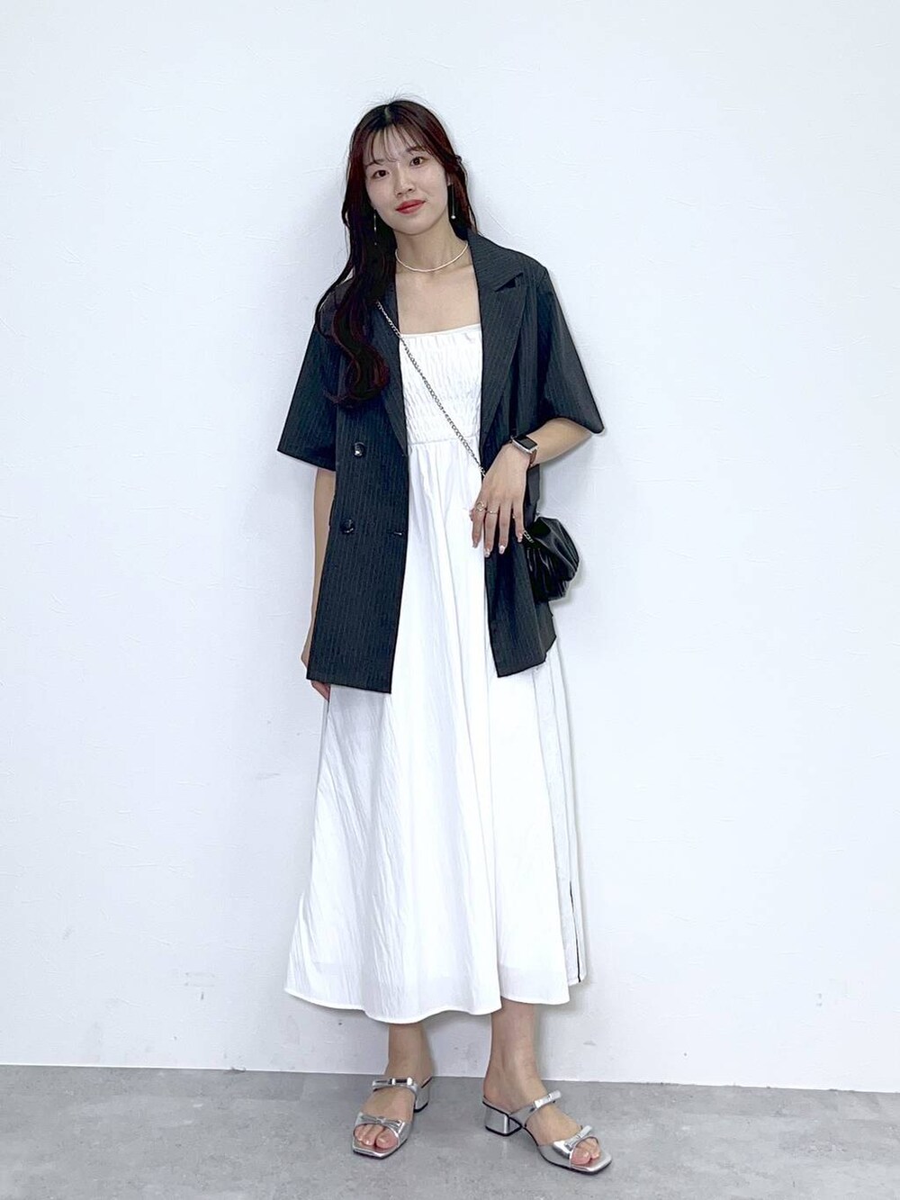ブラック系のショルダーバッグ、シルバー系のサンダル、ホワイト系のワンピースを着用したレディースの春コーディネートの4枚目の写真