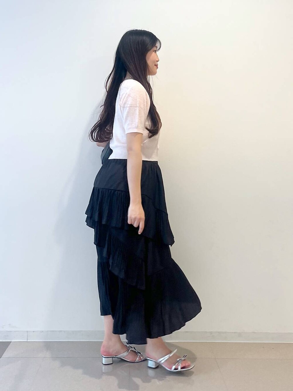 グレー系のショルダーバッグ、ホワイト系のキャミソール、ブラック系のスカートを着用したレディースの春コーディネートの5枚目の写真