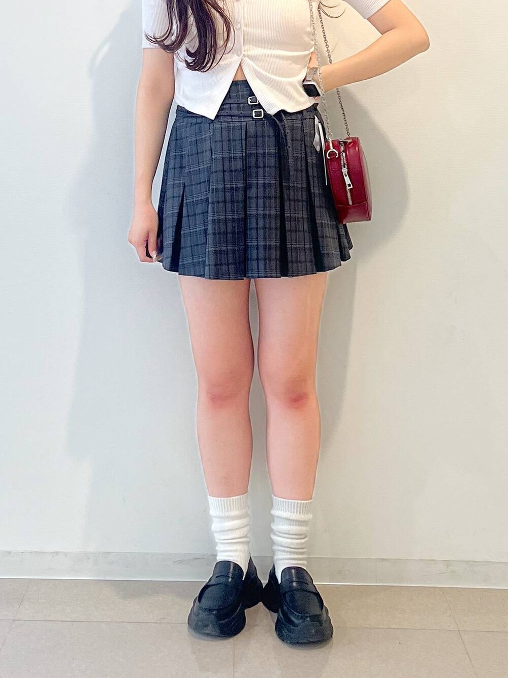 ブラック系のローファー、グレー系のスカート、レッド系のショルダーバッグを着用したレディースの春コーディネートの7枚目の写真