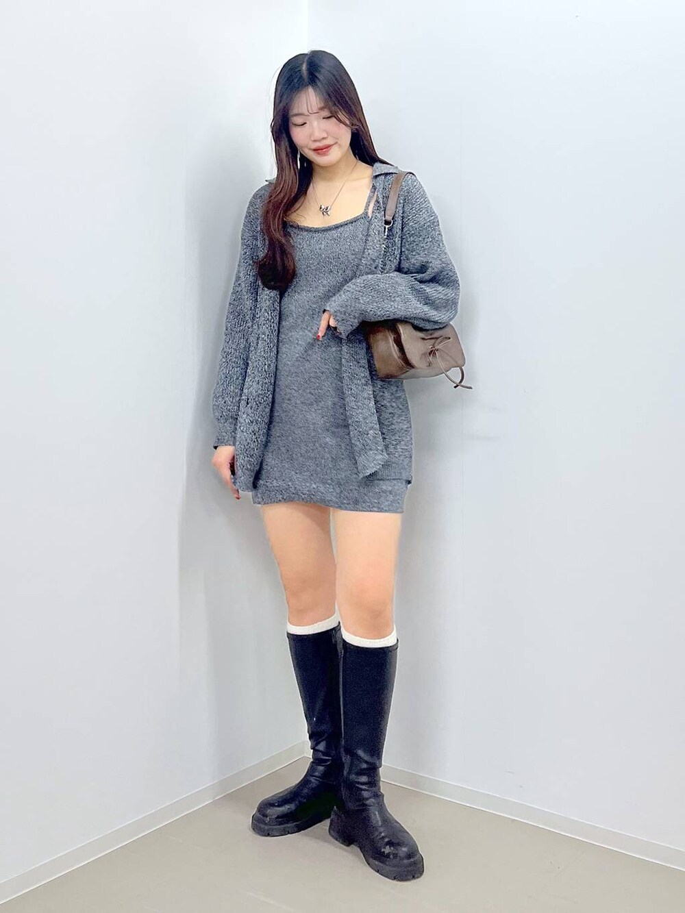 ブラウン系のショルダーバッグ、ホワイト系のキャミソール、ブラック系のブーツを着用したレディースの春コーディネートの8枚目の写真