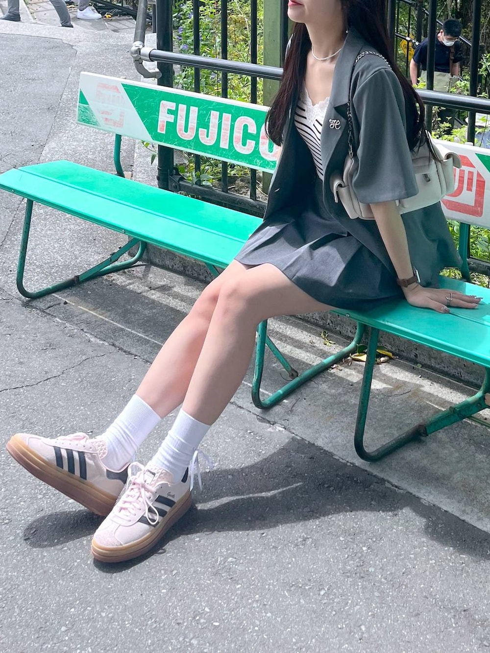 ホワイト系のショルダーバッグ、グレー系のスカート、グレー系のテーラードジャケットを着用したレディースの春コーディネートの2枚目の写真