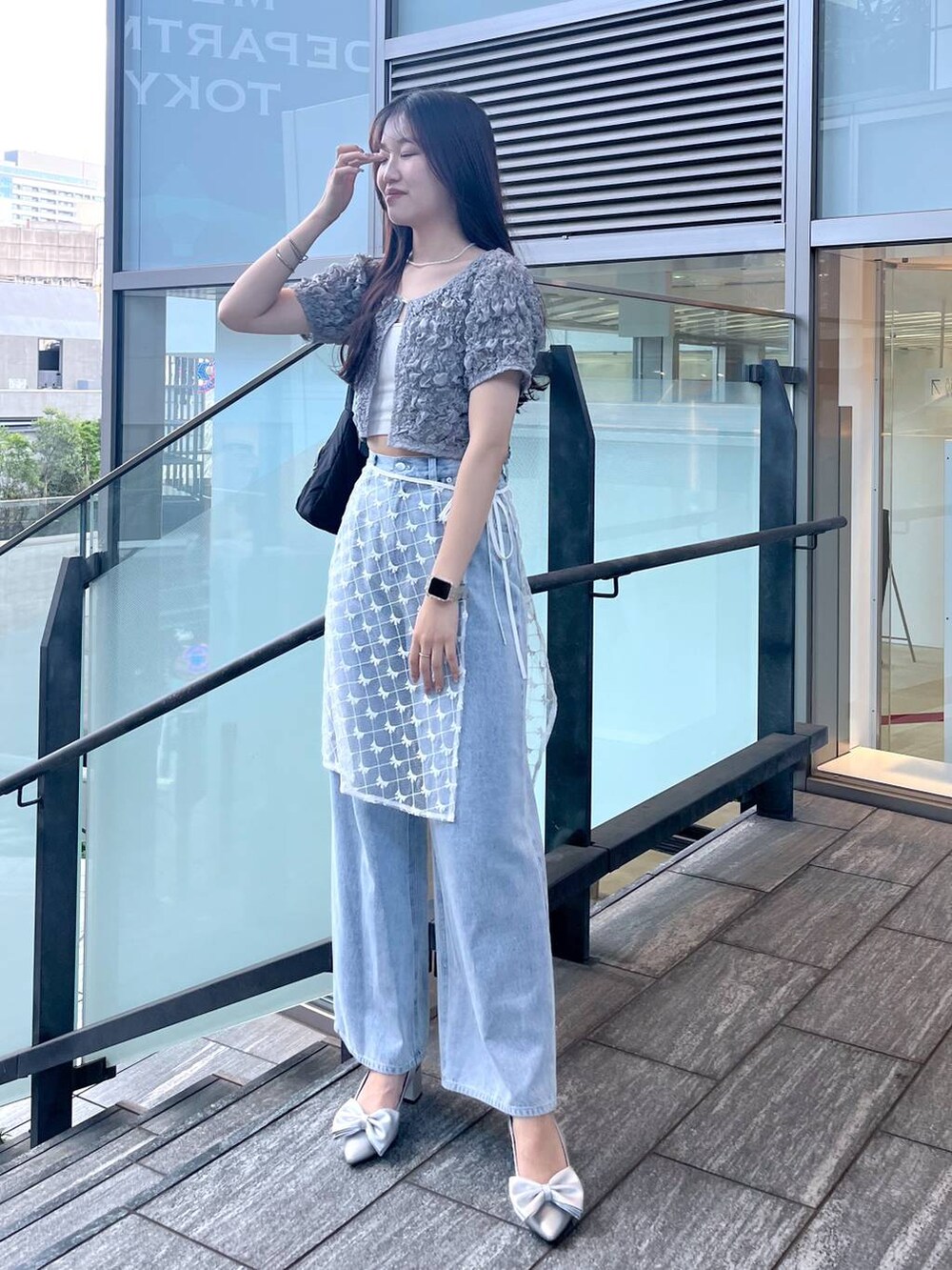 シルバー系のサンダル、ホワイト系のキャミソール、ブルー系のデニムパンツを着用したレディースの夏コーディネートの2枚目の写真