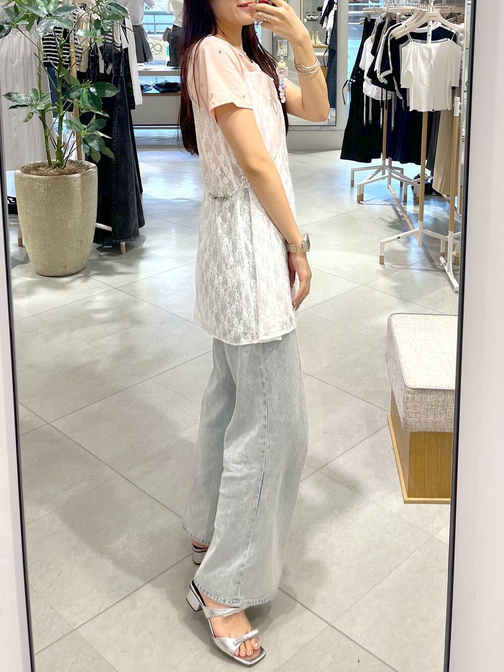 シルバー系のサンダル、ホワイト系のキャミソール、ブルー系のデニムパンツを着用したレディースの春コーディネートの6枚目の写真