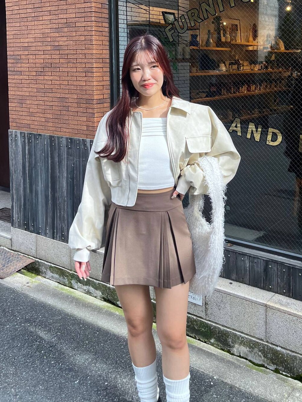 ブラウン系のスカート、ホワイト系のショルダーバッグ、ブラック系のローファーを着用したレディースの秋コーディネートの9枚目の写真