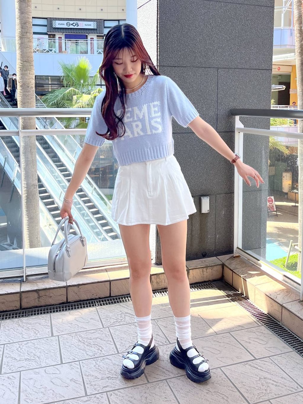 ブラック系のサンダル、ホワイト系のスカート、ブルー系のニット/セーターを着用したレディースの春コーディネートの4枚目の写真